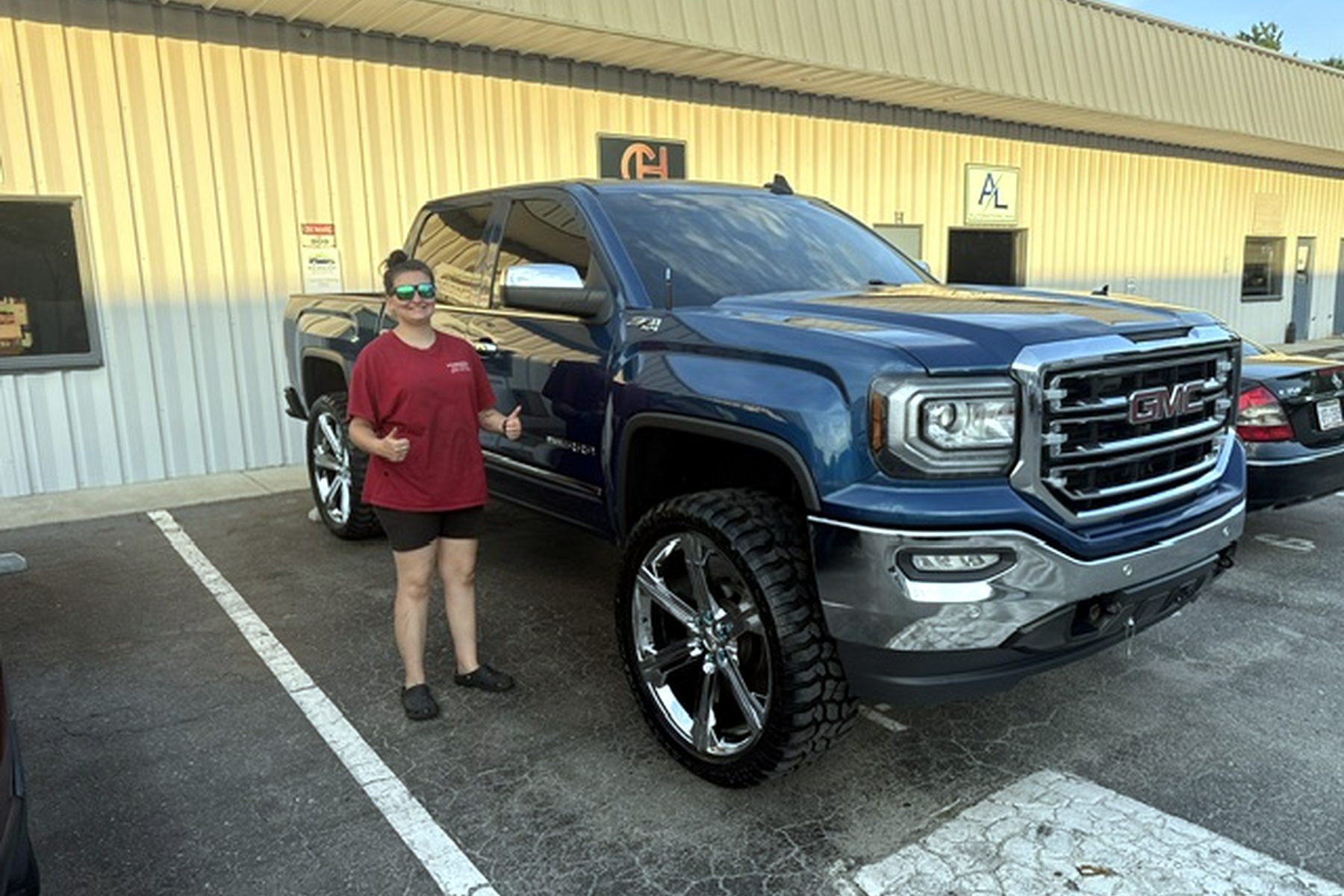 Wilmington Auto Detail team member with a freshly detailed lifted GMC work truck — fleet vehicle cleaning Wilmington NC