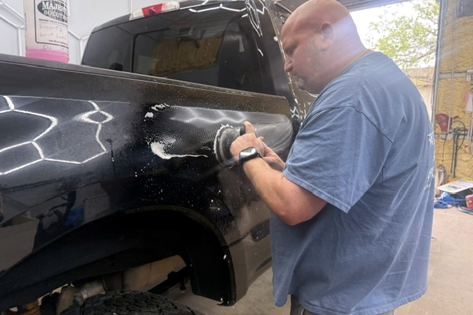 Detailer machine-polishing a black truck — paint correction Wilmington NC, swirl mark removal